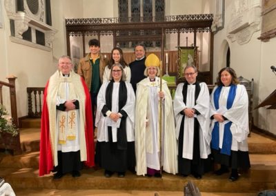 Rev Janet May with her family and fellow clergy